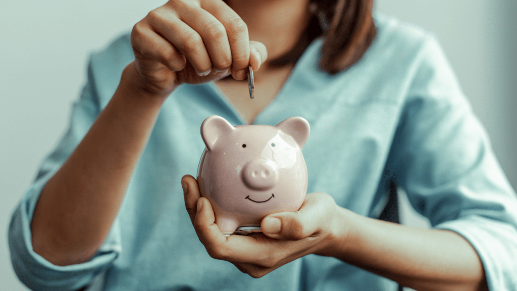 a person putting coins into a piggy bank