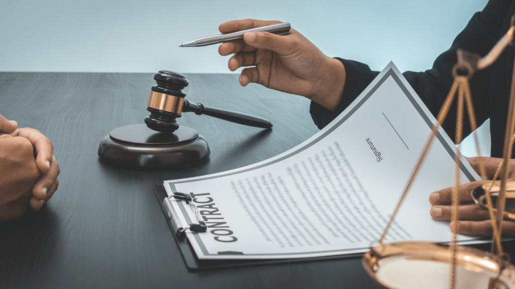 A lawyer holding a book and pen on a desk with a gavel in the background