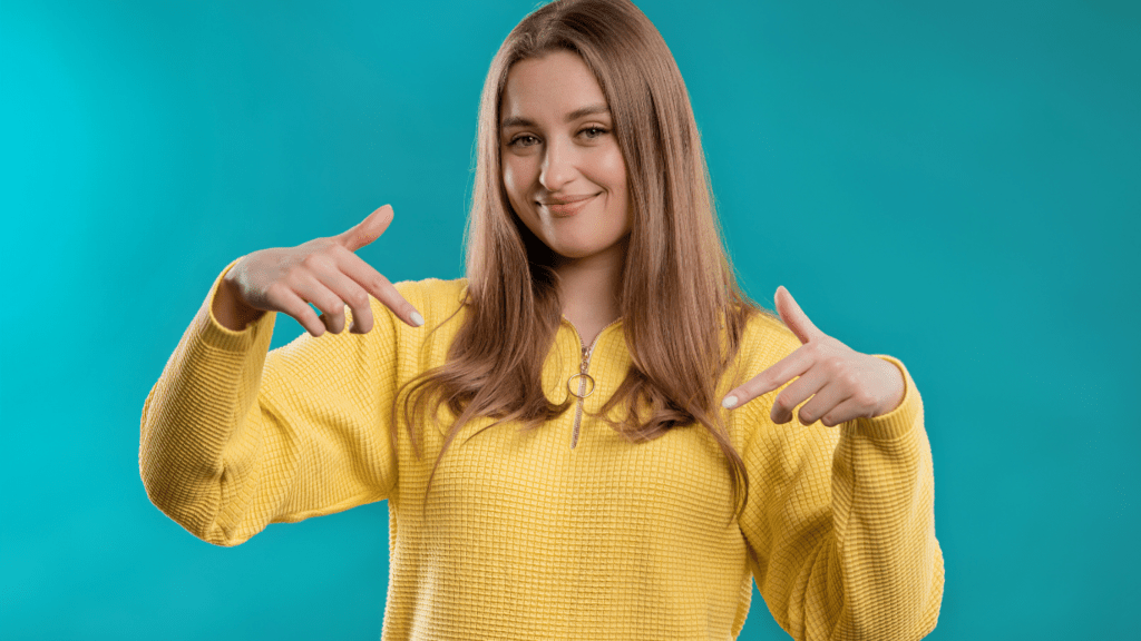 A woman on a blue background pointing down to advertising area