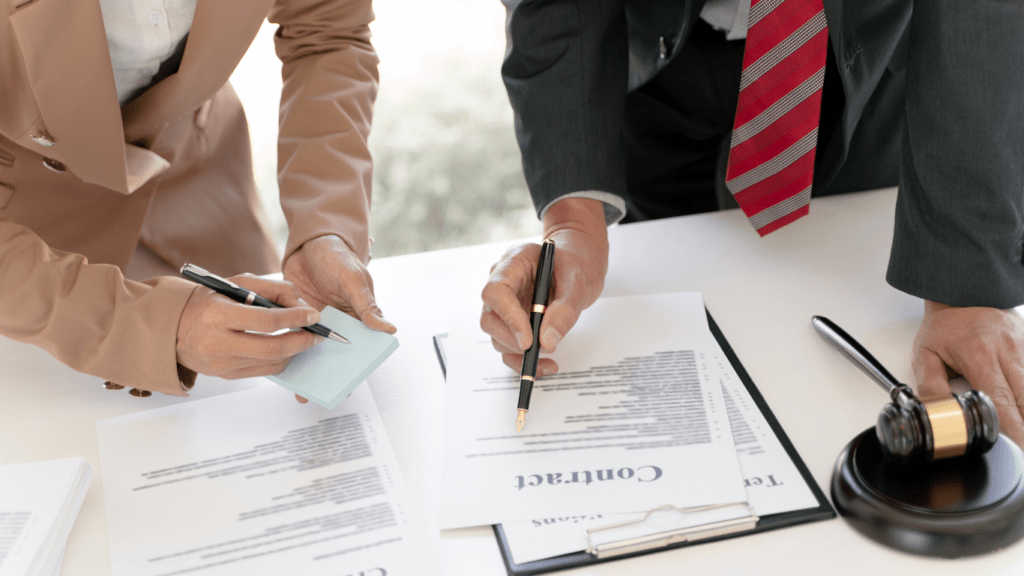 Two business people sitting at a desk with a gavel