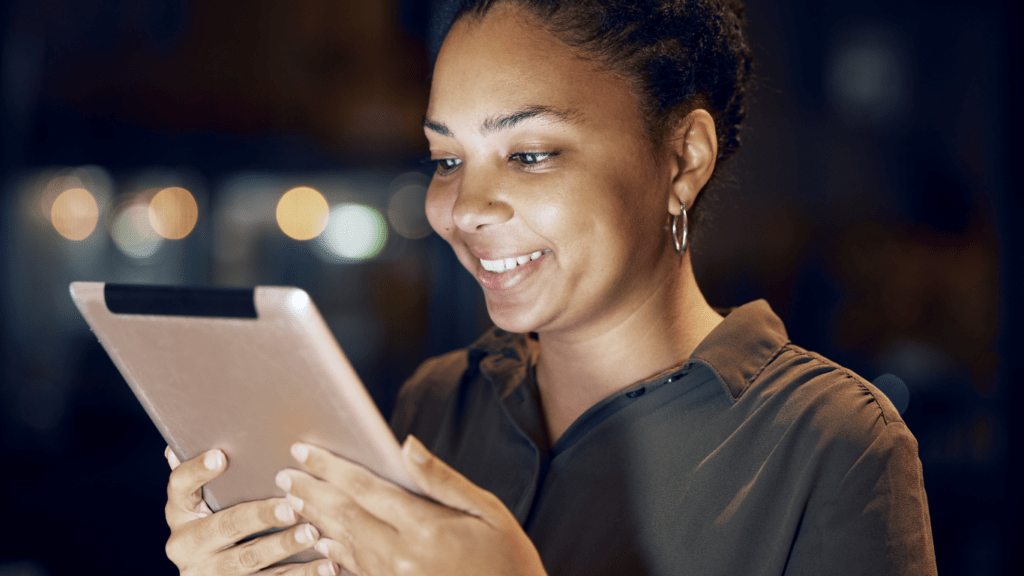 A smiling person using a tablet