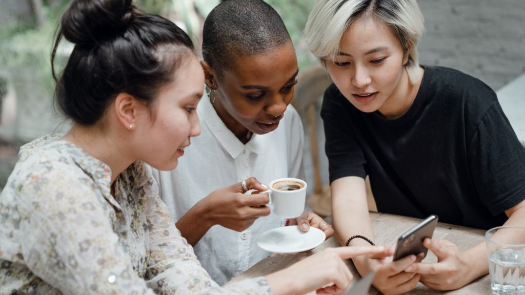 a group of people looking at the cell phone