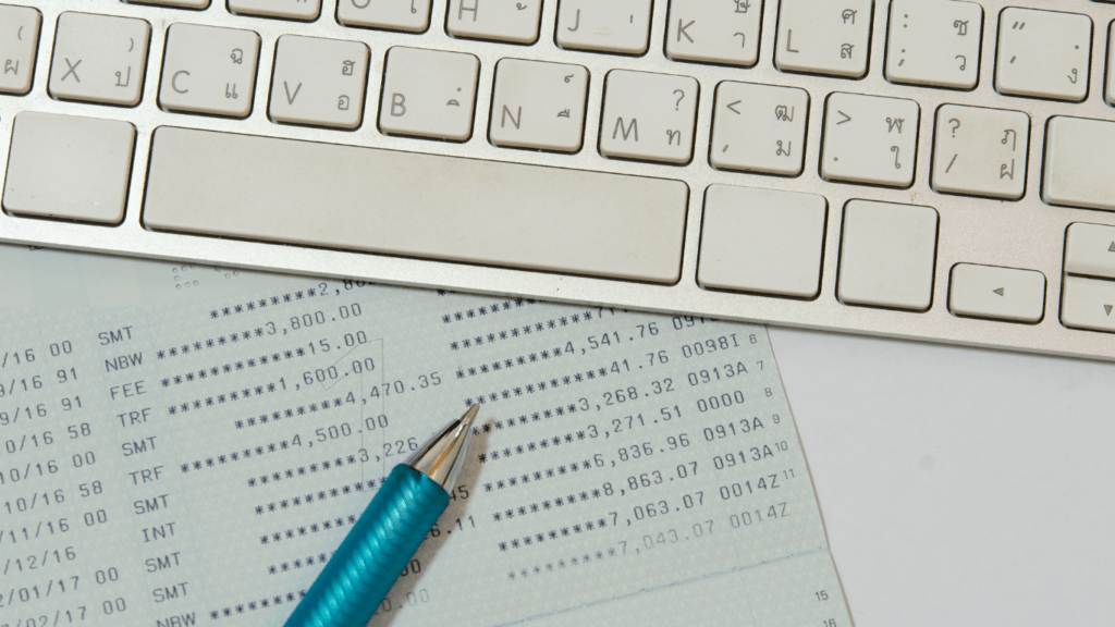 a blue pen is resting on top of a bank statement