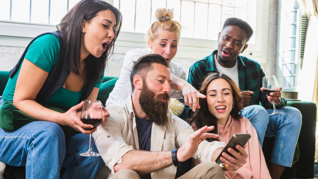 a group of people looking at the cell phone