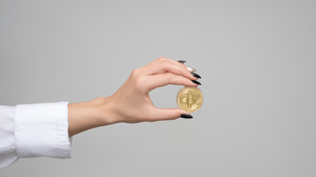 a person holding up a bitcoin in front of their face