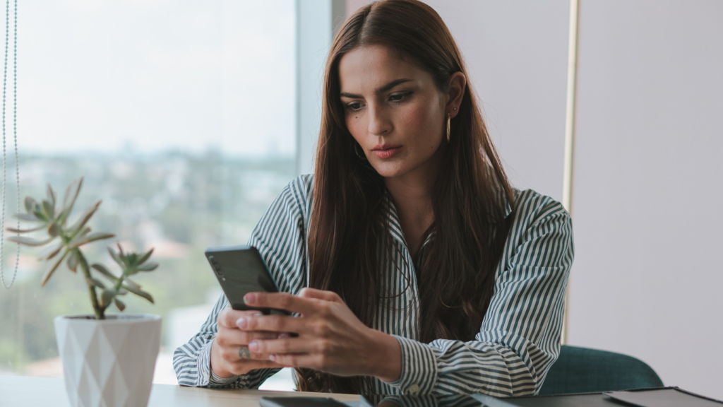 a person in a sweater holding a cell phone