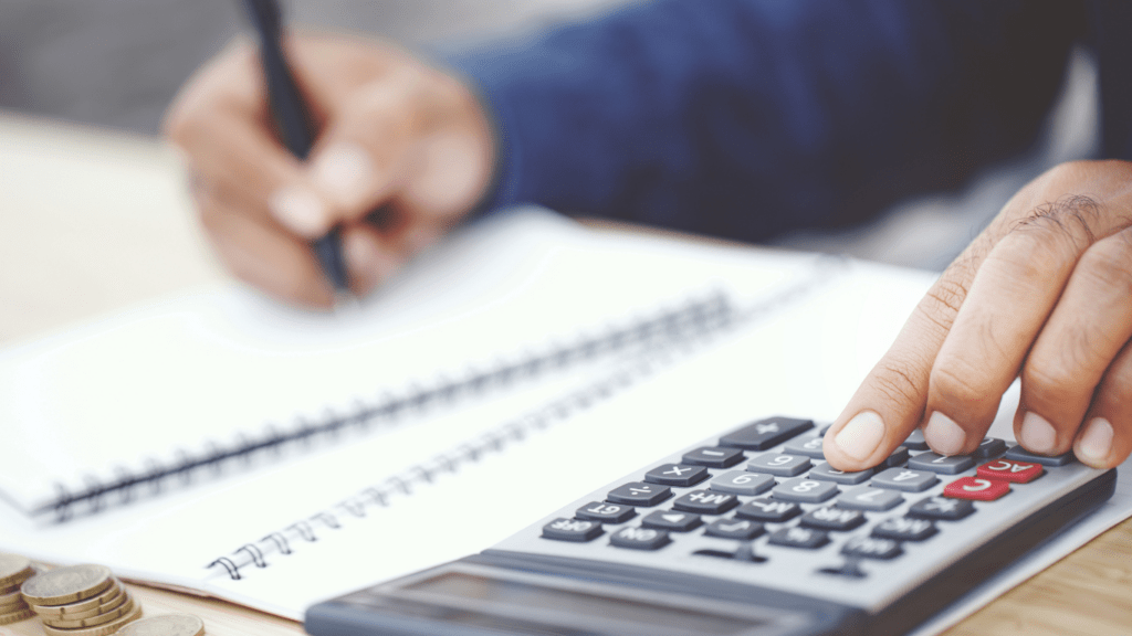 a person is using a calculator while sitting at a desk