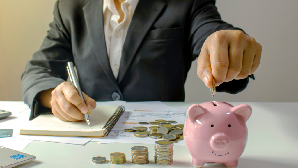 a person  putting coins into a piggy bank