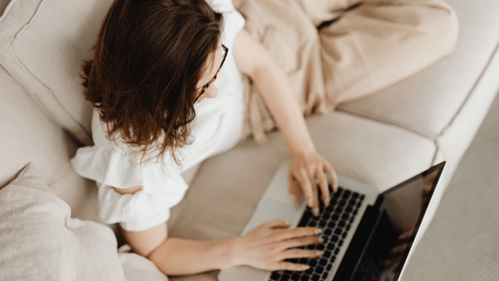 a person sitting on a couch with a laptop