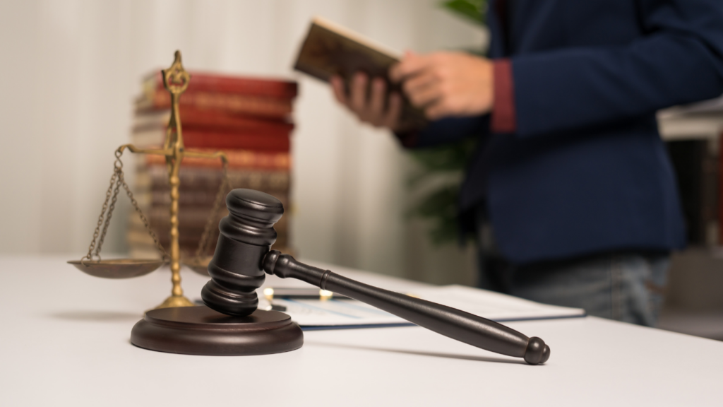 judge's gavel and scales of justice on a table in a courtroom 